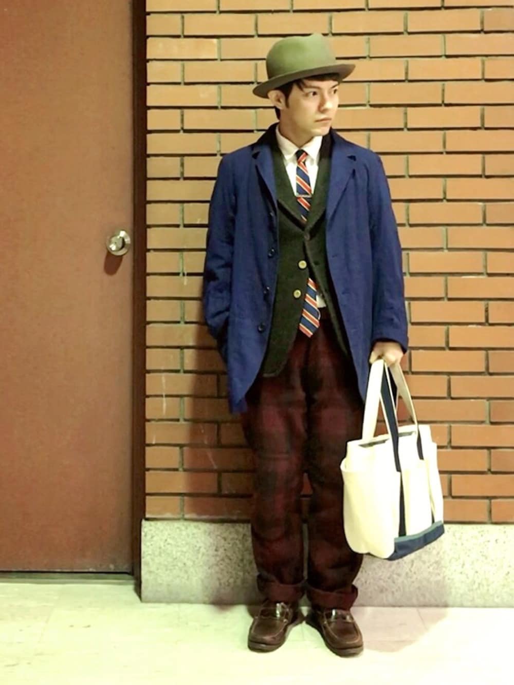 ブラック系のジャケット/アウター、ブラウン系のモカシン/デッキシューズ、ゴールド系のネクタイピンを着用したメンズの冬コーディネートの1枚目の写真