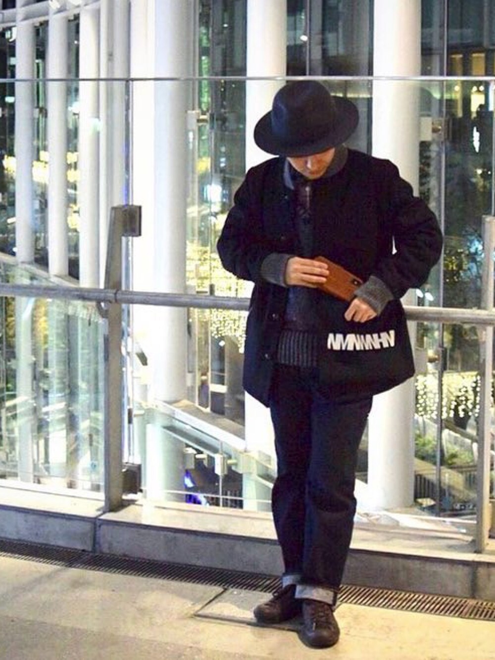 ブラック系のショルダーバッグ、ブルー系のベスト、ブルー系のデニムパンツを着用したメンズの冬コーディネートの1枚目の写真