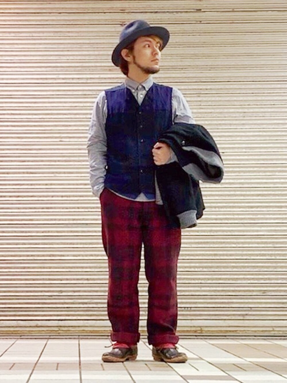 ブルー系のベスト、レッド系のその他シューズ、グレー系のハットを着用したメンズの冬コーディネートの1枚目の写真