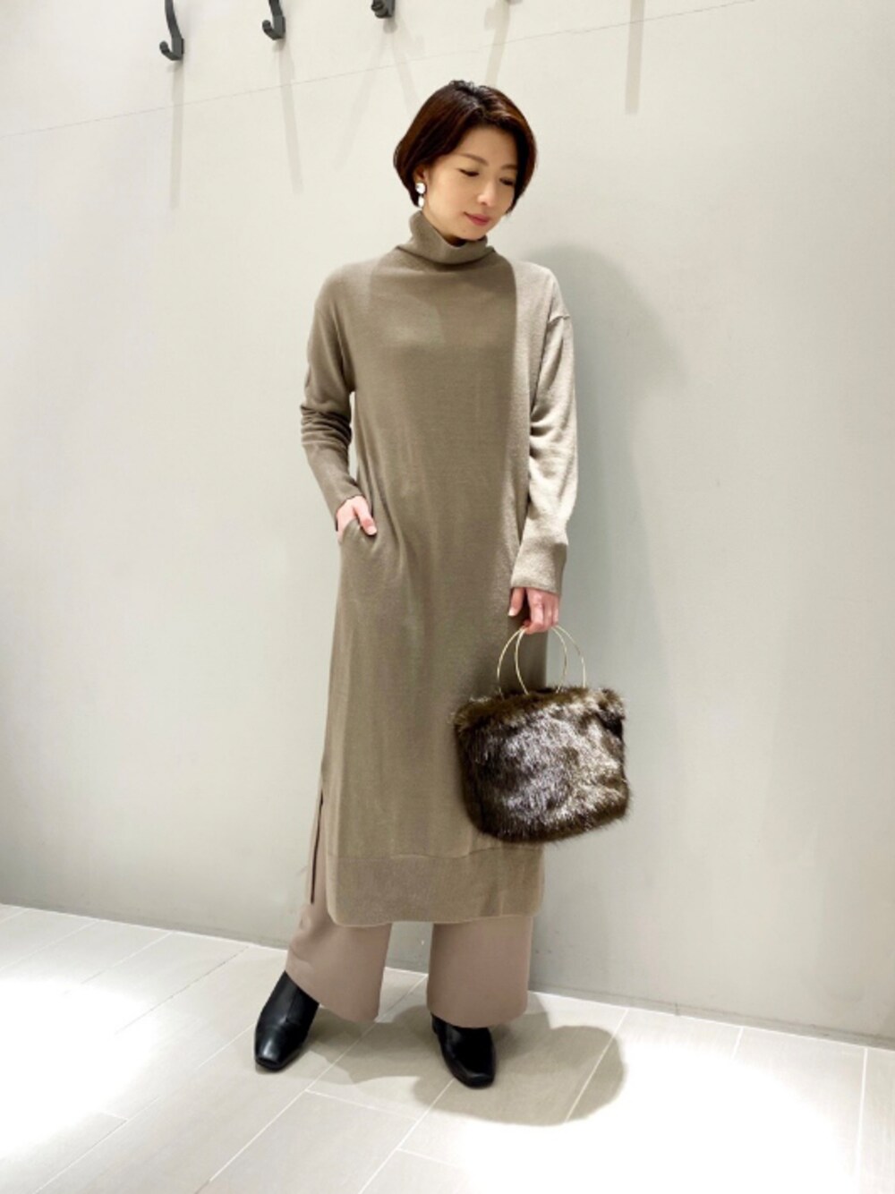 ブラウン系のワンピース、ブラック系のブーツ、ベージュ系のその他パンツを着用したレディースの冬コーディネートの1枚目の写真