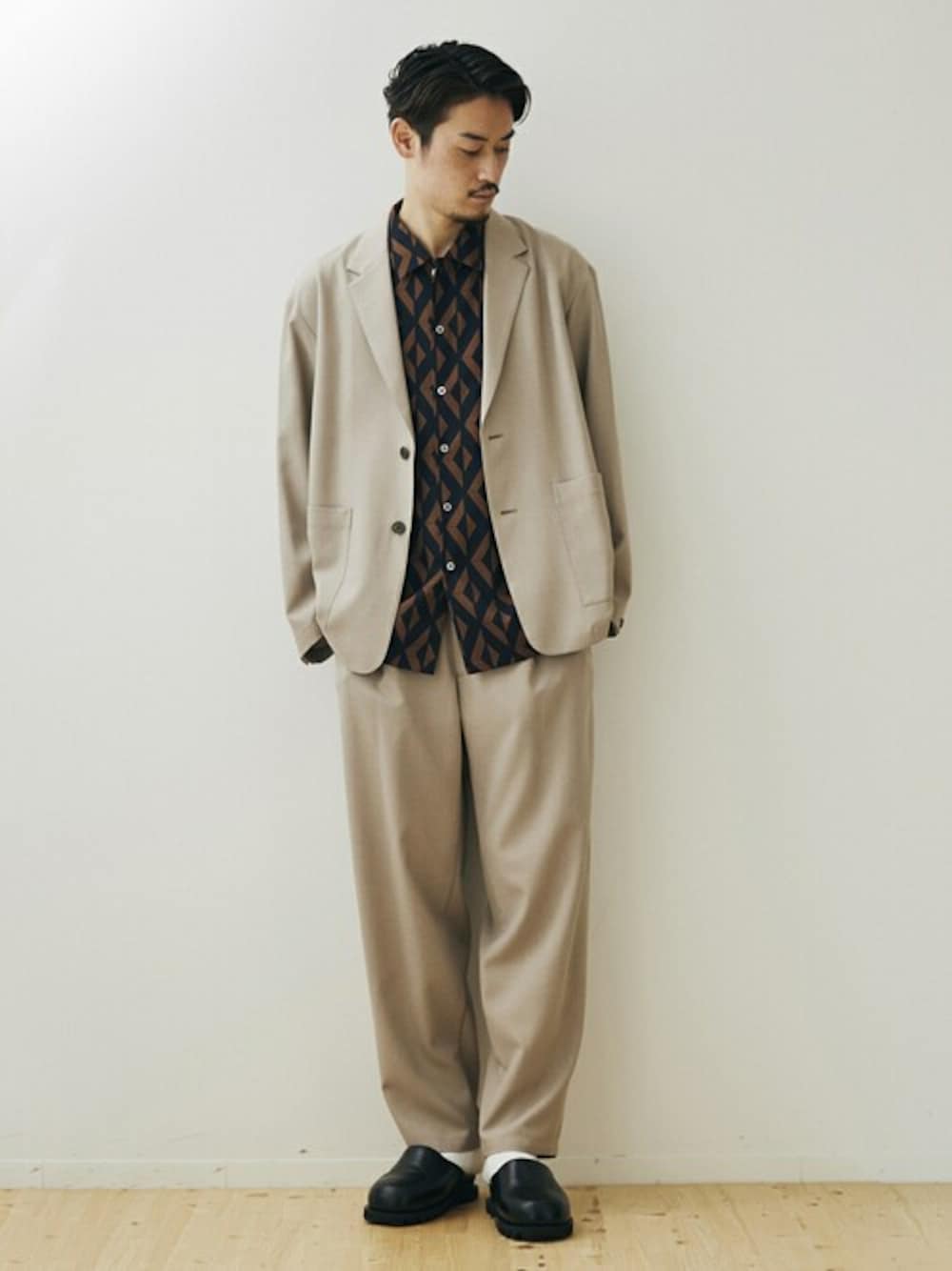 ベージュ系のセットアップ、ブルー系のシャツ/ブラウス、ブラック系のサンダルを着用したメンズの春コーディネートの1枚目の写真