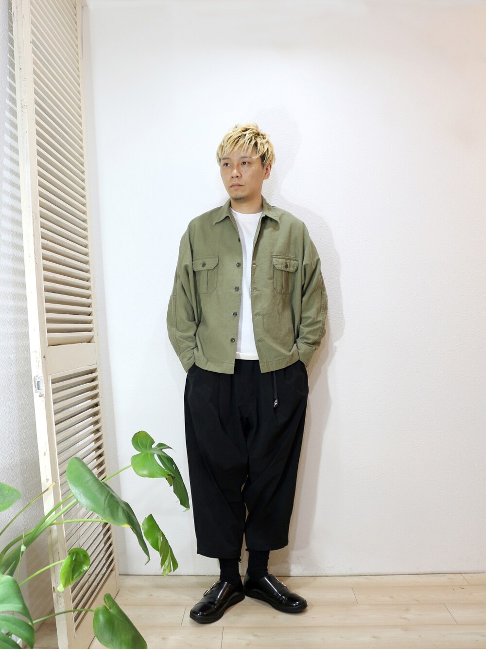 グリーン系のミリタリージャケット、ホワイト系のTシャツ/カットソー、ブラック系のその他パンツを着用したメンズの秋コーディネートの1枚目の写真