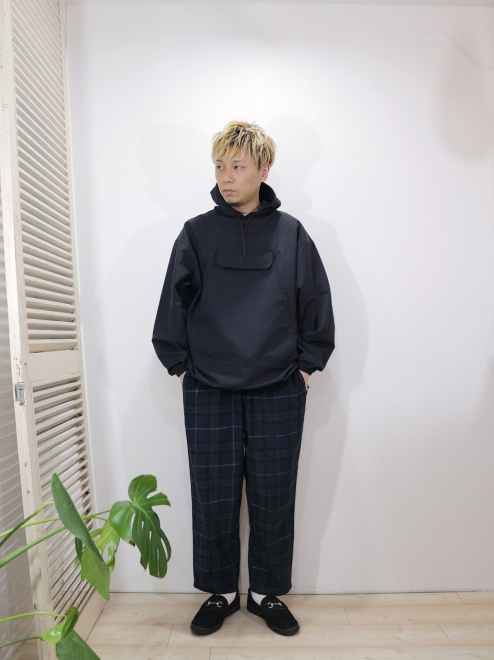 ブラック系のマウンテンパーカー、グリーン系のその他パンツ、ブラック系のローファーを着用したメンズの秋コーディネートの1枚目の写真