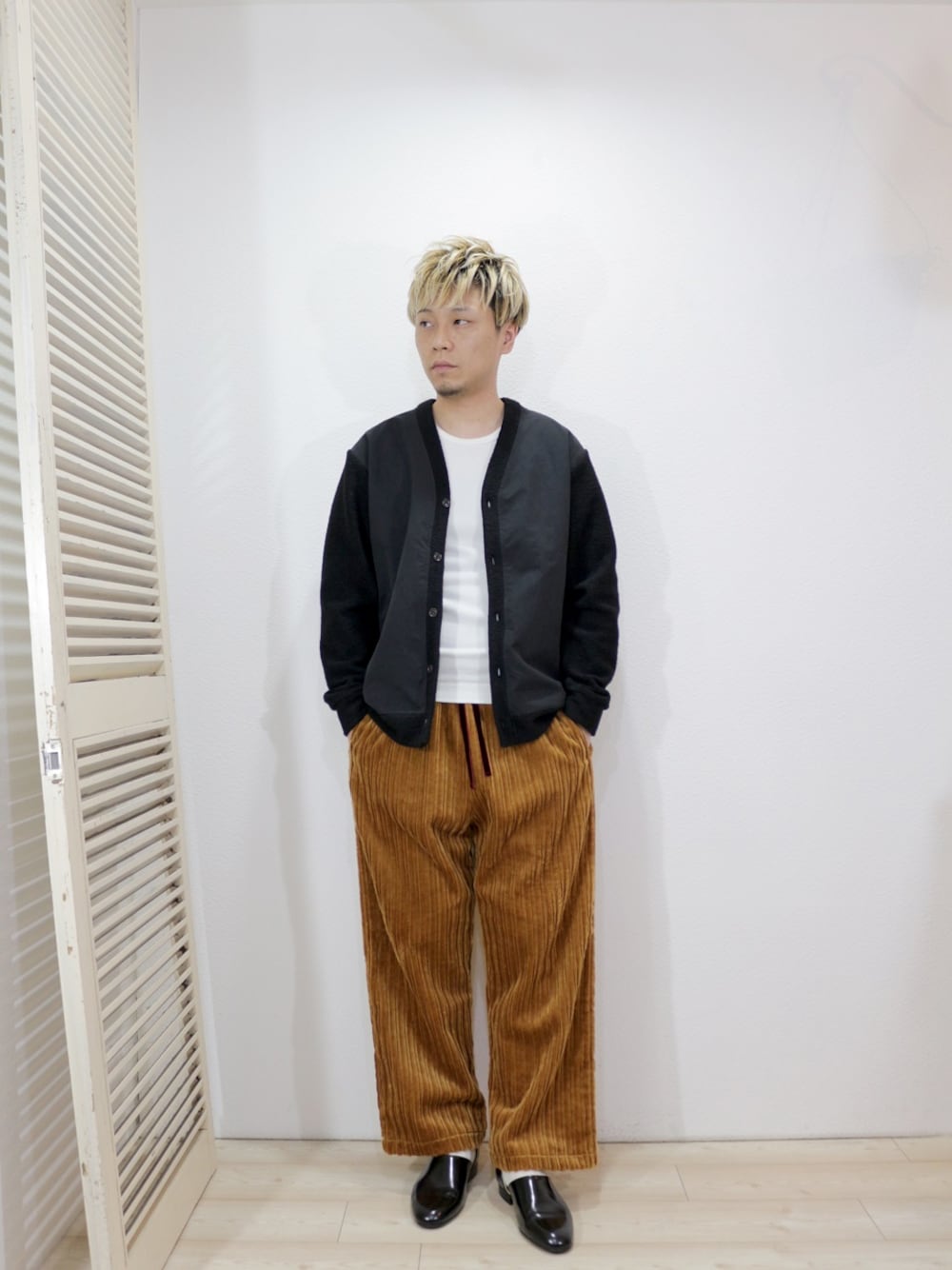 ブラック系のカーディガン/ボレロ、ホワイト系のTシャツ/カットソー、ベージュ系のその他パンツを着用したメンズの冬コーディネートの1枚目の写真