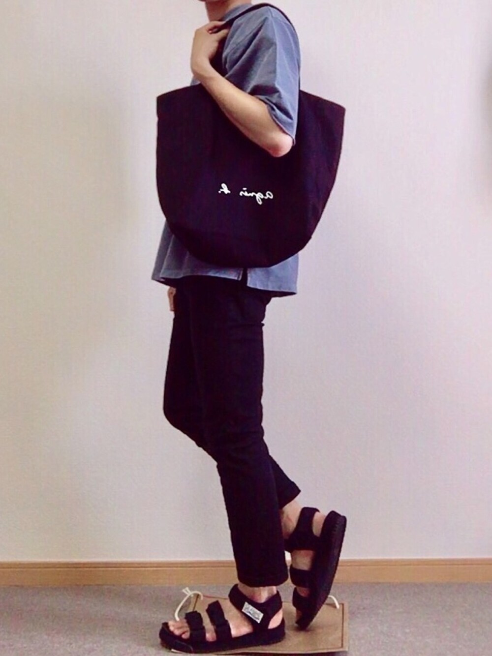 ブルー系のサンダル、ブラック系のチノパンツ、ブラック系のトートバッグを着用したメンズの春コーディネートの1枚目の写真