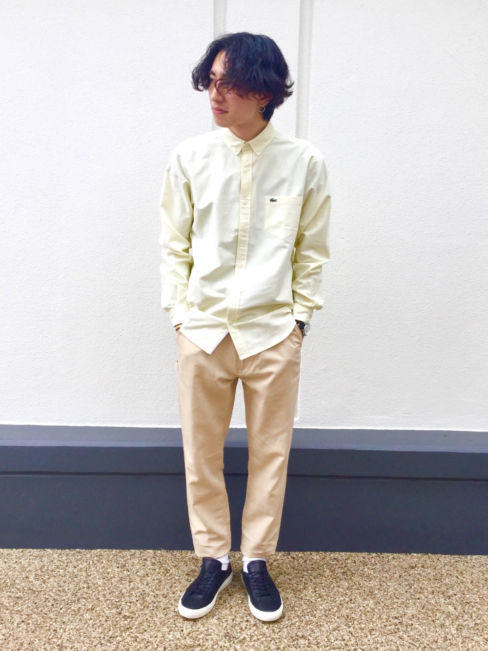 イエロー系のシャツ/ブラウス、ベージュ系のチノパンツ、ブラック系のスニーカーを着用したメンズの春コーディネートの1枚目の写真