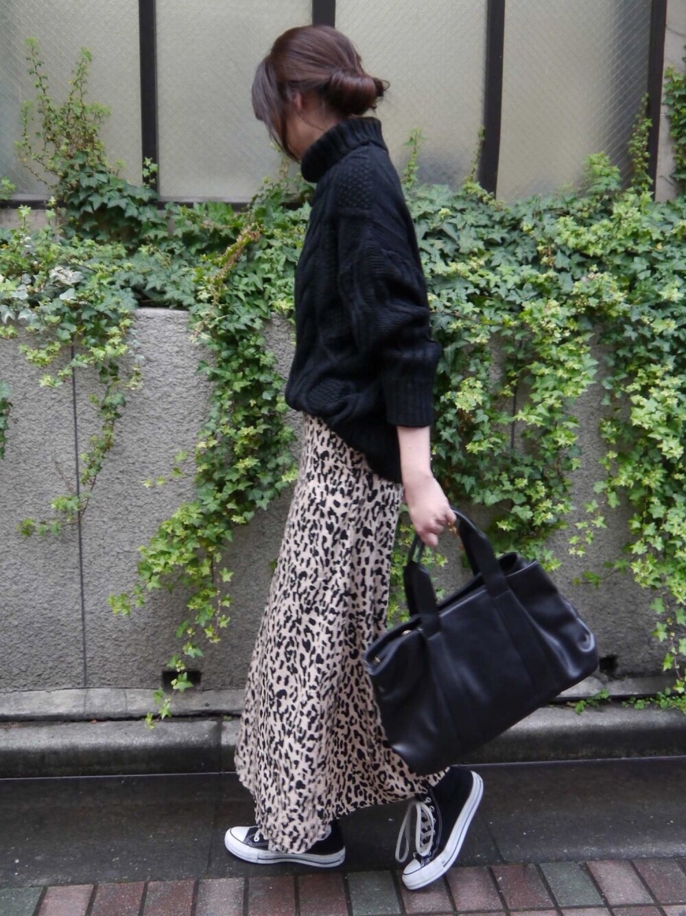 ブラック系のニット/セーター、ベージュ系のスカート、ブラック系のスニーカーを着用したレディースの冬コーディネートの1枚目の写真