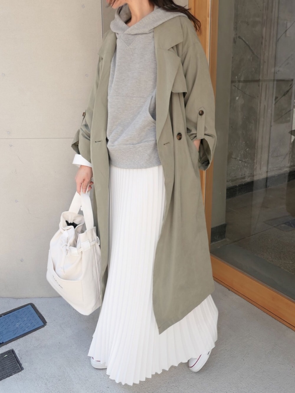 グレー系のパーカー、ホワイト系のTシャツ/カットソー、ホワイト系のスカートを着用したレディースの冬コーディネートの1枚目の写真
