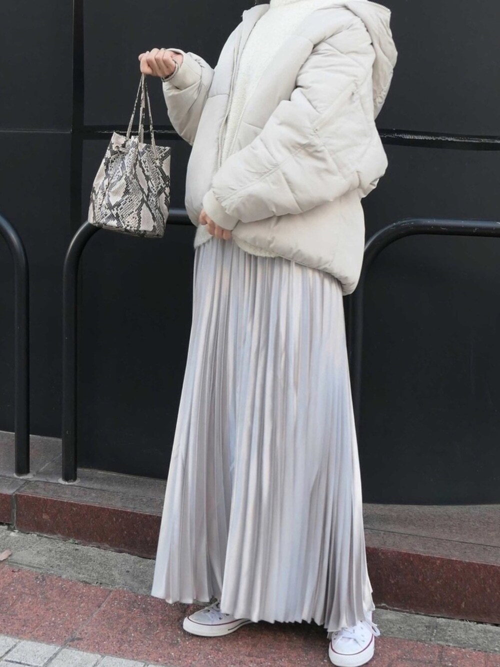 ホワイト系のダウンジャケット/コート、ホワイト系のニット/セーター、シルバー系のスカートを着用したレディースの秋コーディネートの1枚目の写真