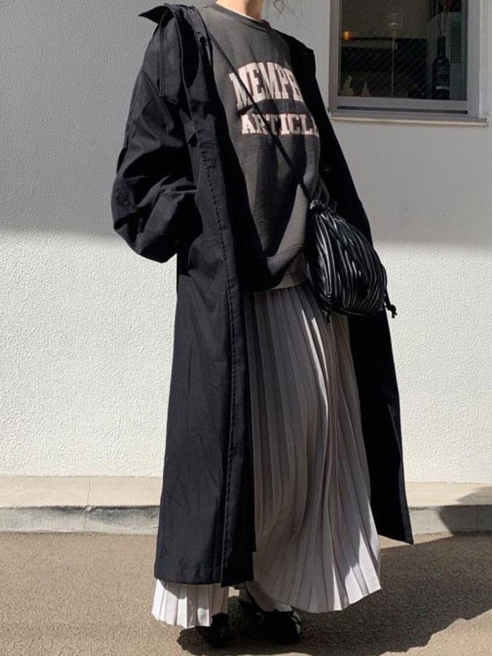 ブラック系のトレンチコート、ホワイト系のTシャツ/カットソー、ブラック系のスウェットを着用したレディースの春コーディネートの1枚目の写真