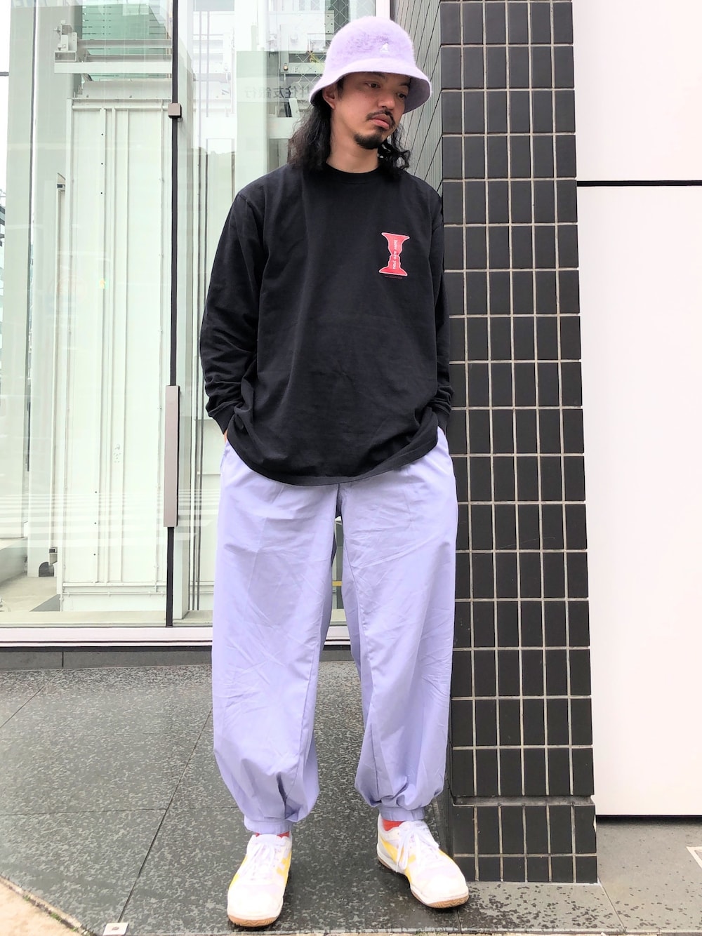 ブラック系のTシャツ/カットソー、パープル系のパンツ、ホワイト系のスニーカーを着用したメンズの春コーディネートの1枚目の写真