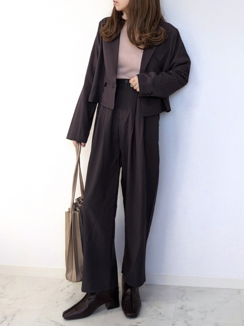 ベージュ系のTシャツ/カットソー、グレー系のテーラードジャケット、ブラウン系のブーツを着用したレディースの秋コーディネートの1枚目の写真