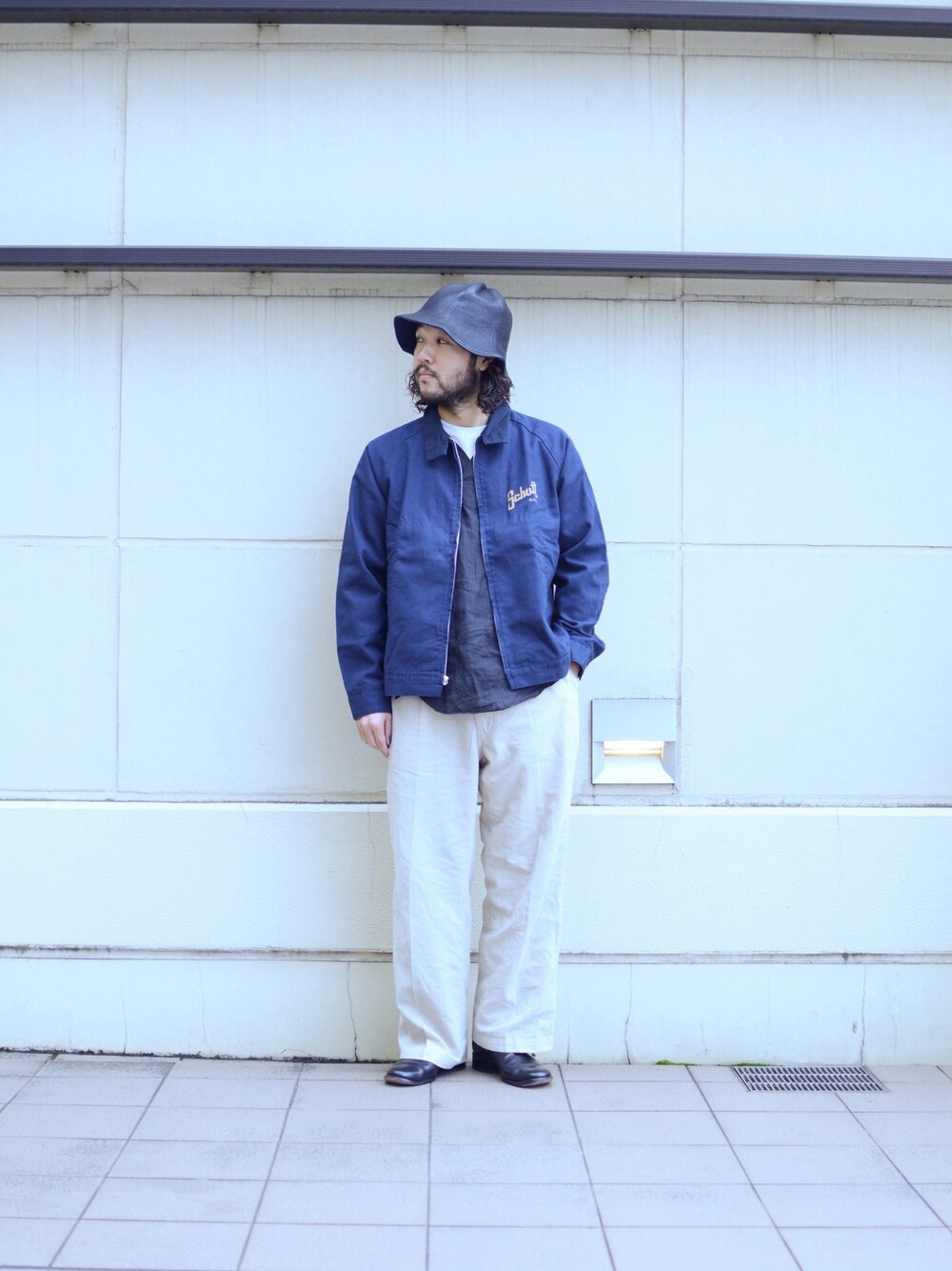 ブルー系のブルゾン、ホワイト系のパンツを着用したメンズの春コーディネートの1枚目の写真