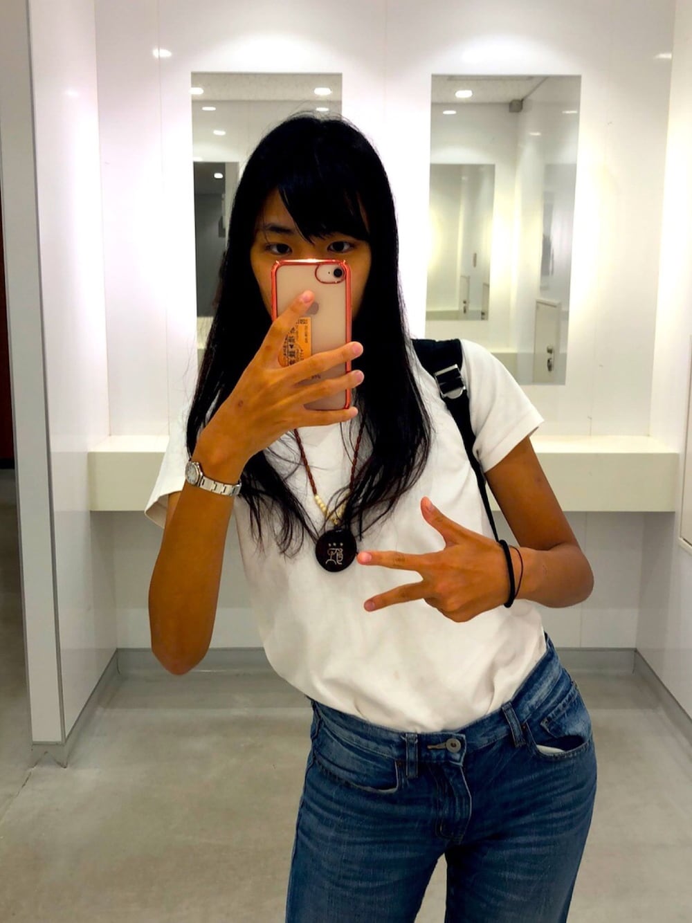 ブルー系のデニムパンツ、ホワイト系のTシャツ/カットソー、ブラック系のバックパック/リュックを着用したレディースの秋コーディネートの1枚目の写真