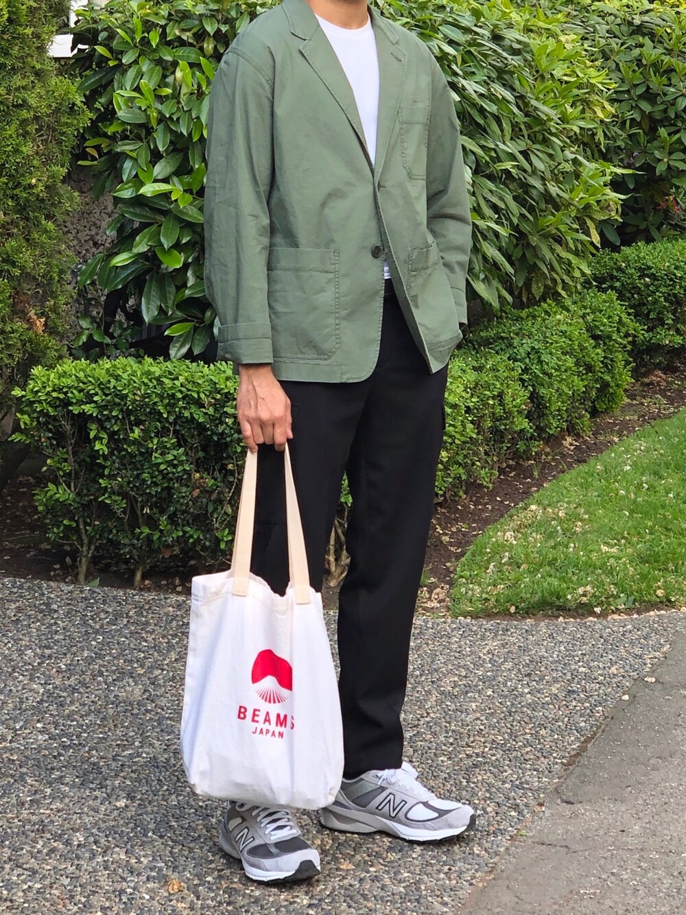 グレー系のスニーカー、ベージュ系のトートバッグ、ブラック系のその他パンツを着用したメンズの秋コーディネートの1枚目の写真