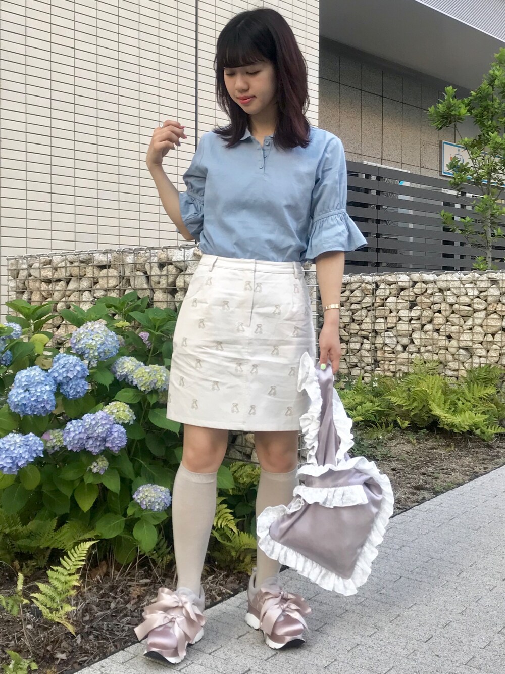 ピンク系のスニーカー、ブルー系のシャツ/ブラウス、ホワイト系のスカートを着用したレディースの春コーディネートの1枚目の写真