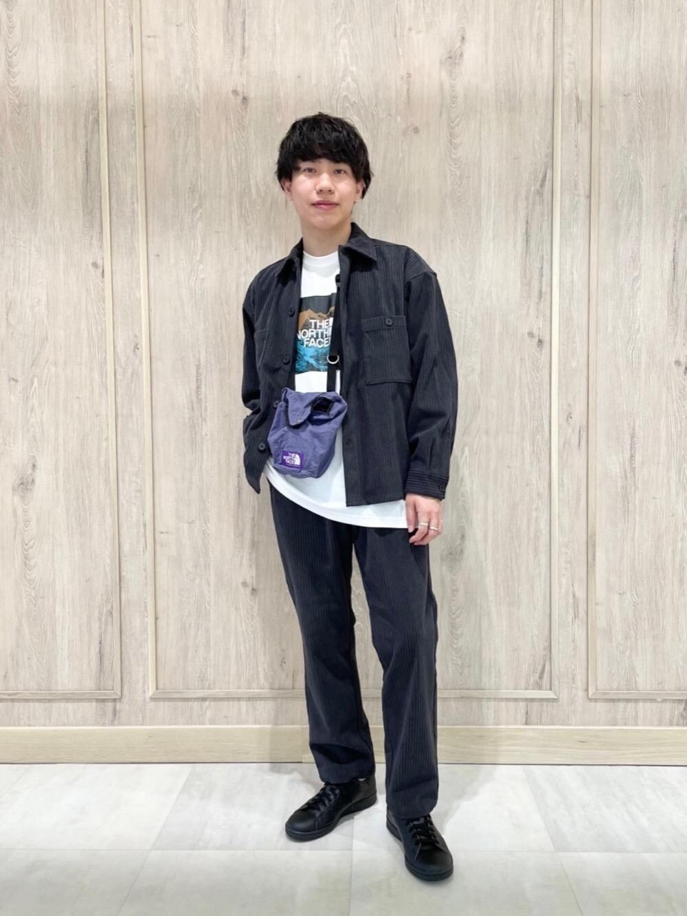 パープル系のショルダーバッグ、ブラック系のスニーカー、ホワイト系のTシャツ/カットソーを着用したメンズの秋コーディネートの1枚目の写真