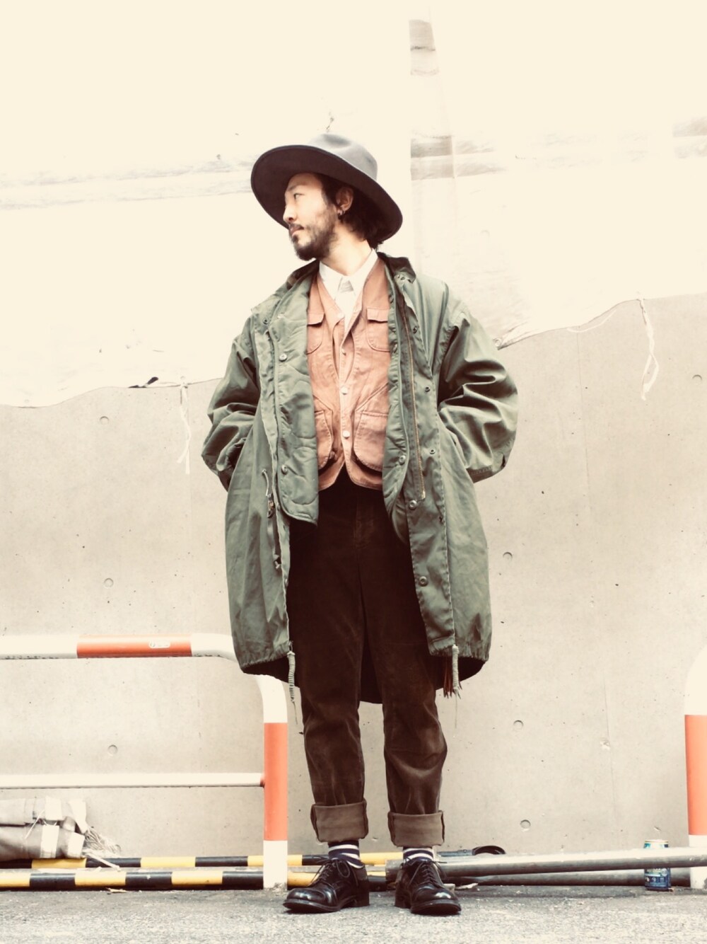 グリーン系のモッズコート、ブラウン系のベスト、ホワイト系のTシャツ/カットソーを着用したメンズの冬コーディネートの1枚目の写真