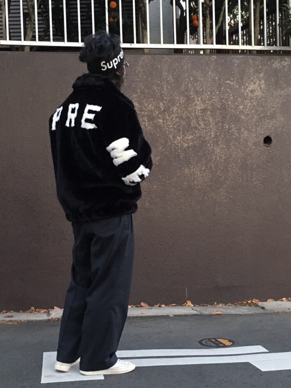 ブラック系のブルゾン、グレー系のニット/セーター、ブルー系のスラックスを着用したメンズの冬コーディネートの1枚目の写真