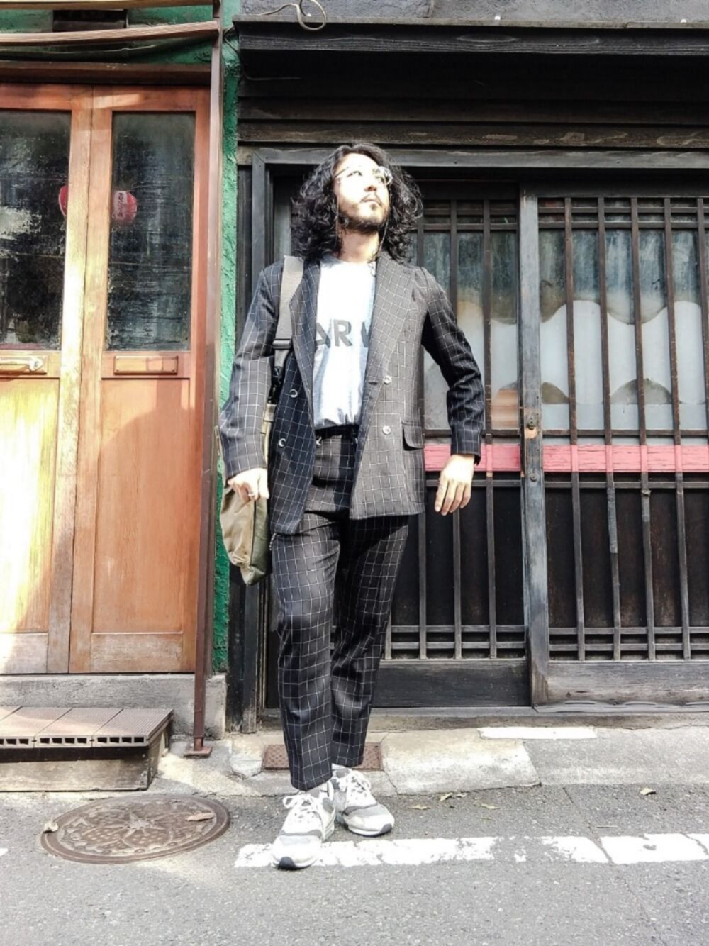 グレー系のTシャツ/カットソー、グレー系のスニーカー、ブラック系のセットアップを着用したメンズの秋コーディネートの1枚目の写真