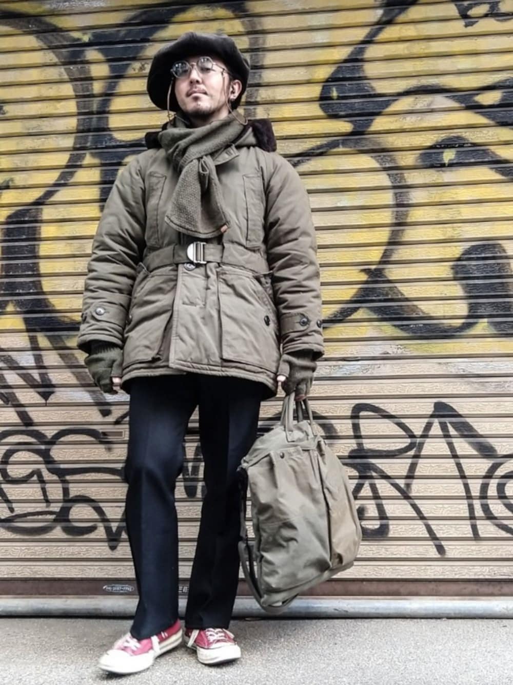 グリーン系のミリタリージャケット、ブラック系のその他パンツ、グリーン系のショルダーバッグを着用したメンズの冬コーディネートの1枚目の写真