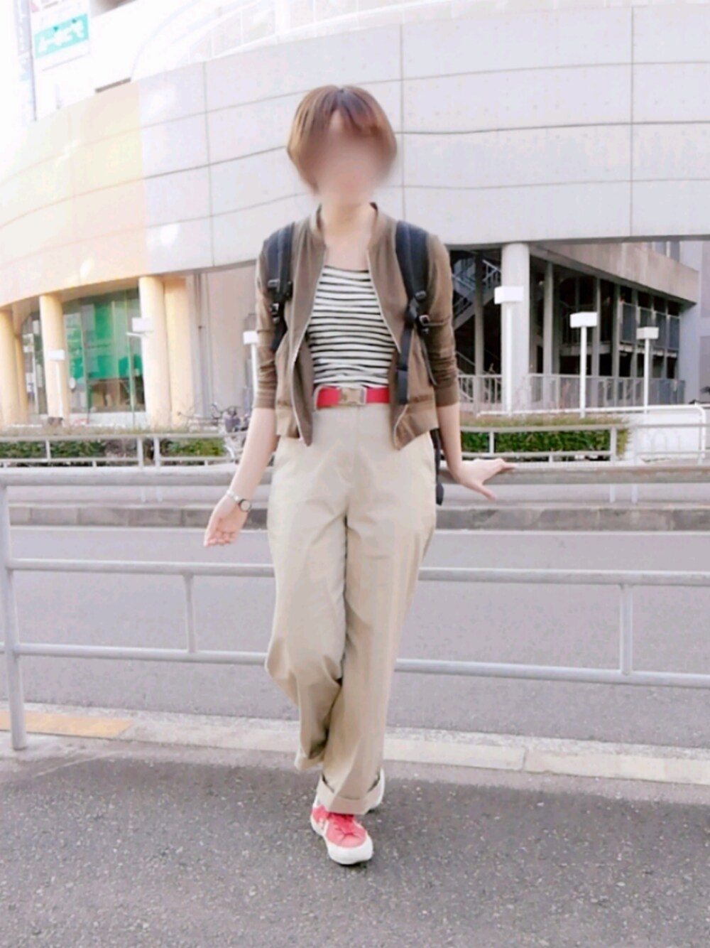 レッド系のスニーカー、グリーン系のブルゾン、ベージュ系のその他パンツを着用したレディースの春コーディネートの1枚目の写真