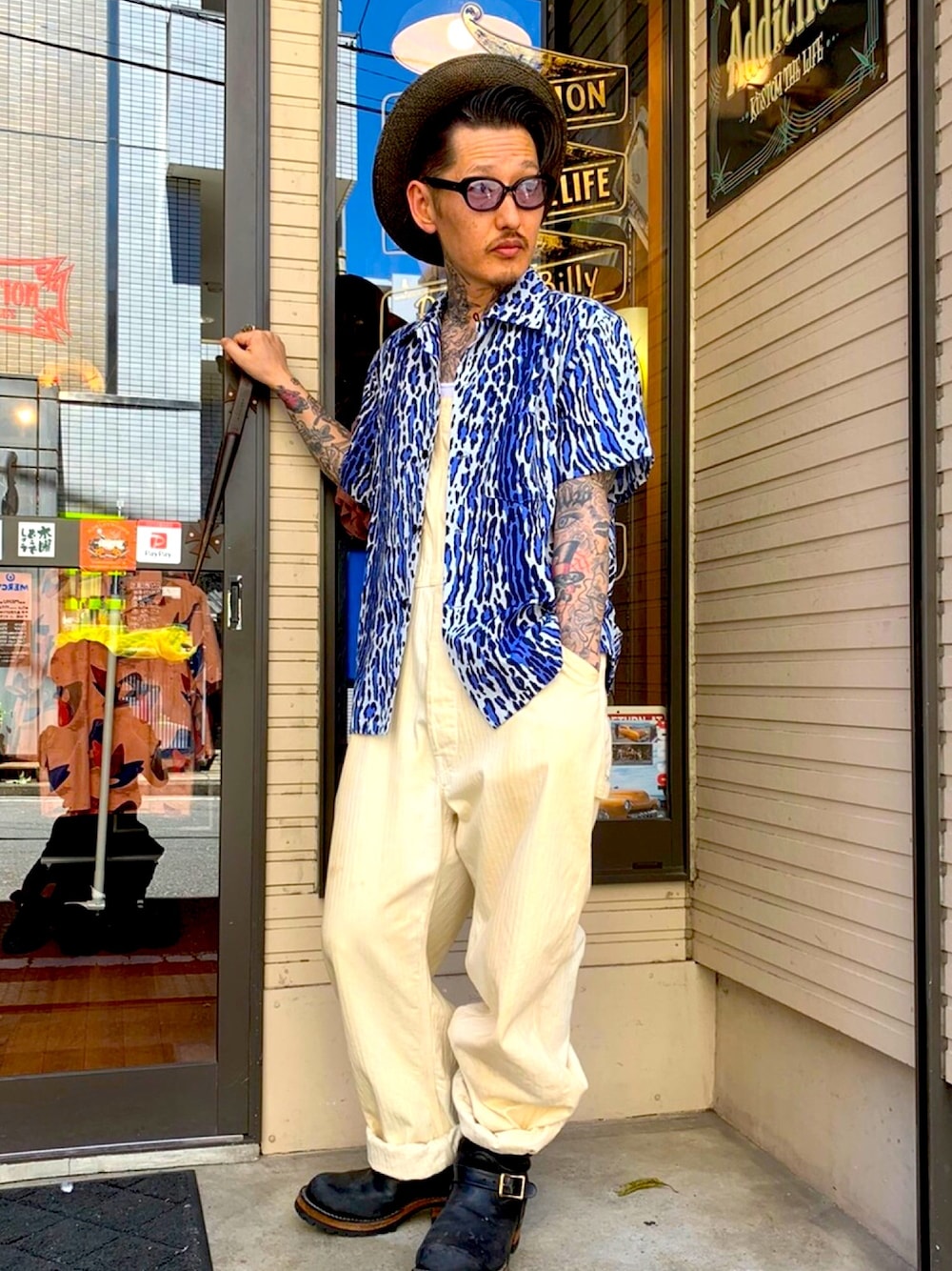 ブルー系のシャツ/ブラウス、ベージュ系のサロペット/オーバーオール、ブラック系のブーツを着用したメンズの夏コーディネートの1枚目の写真