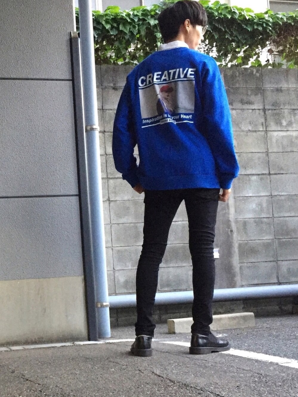 ブルー系のスウェット、ブラック系のデニムパンツ、ブラック系のスリッポンを着用したメンズの秋コーディネートの1枚目の写真