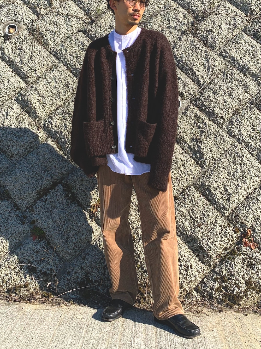 ブラウン系のカーディガン/ボレロ、ホワイト系のシャツ/ブラウス、ブラウン系のパンツを着用したメンズの冬コーディネートの1枚目の写真