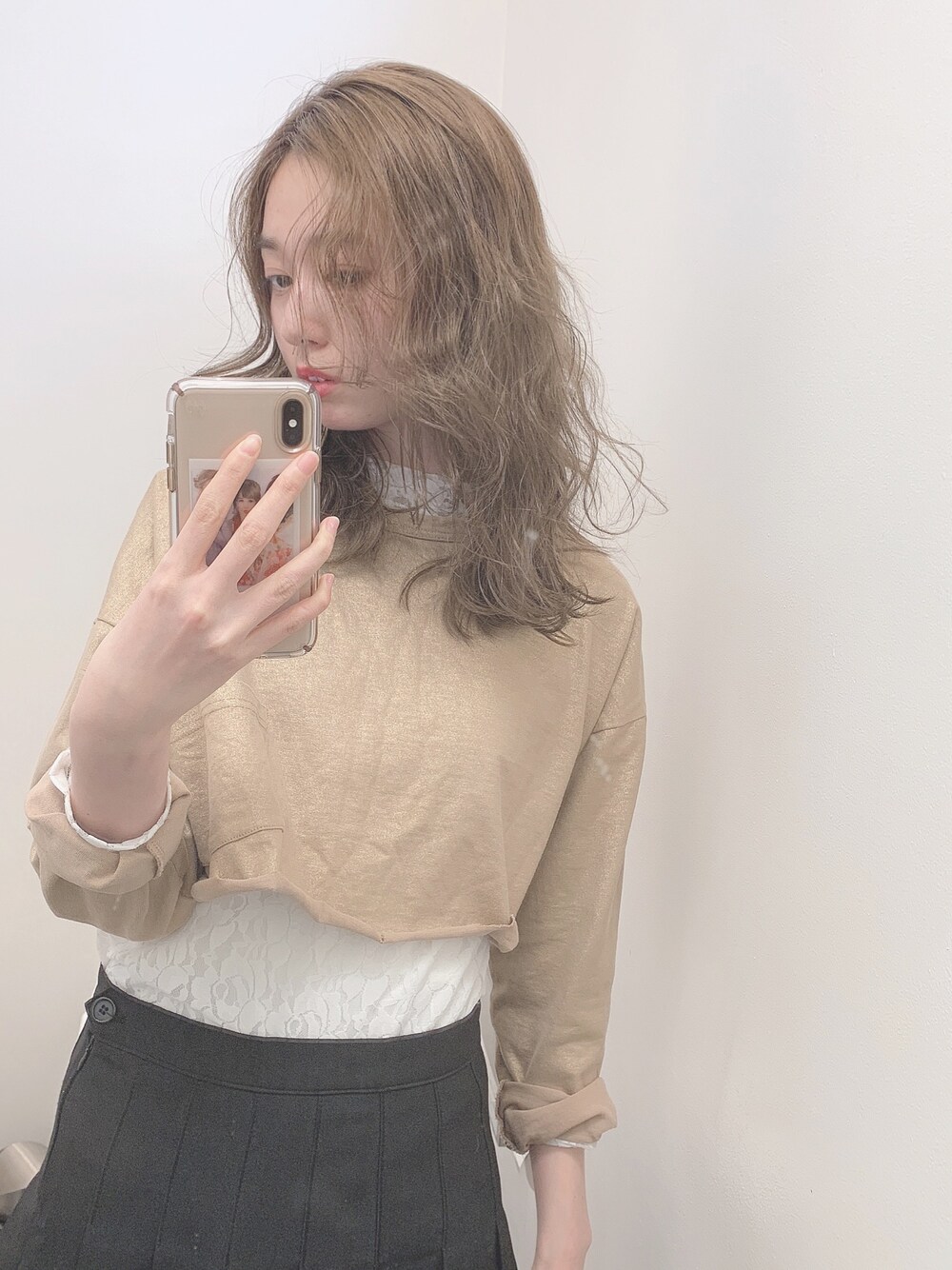 ベージュ系のスウェット、ブラック系のスカートを着用したレディースの春コーディネートの1枚目の写真