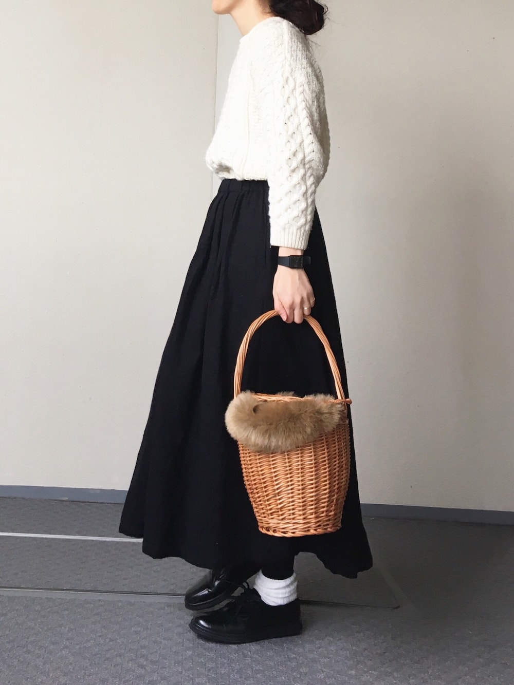 ホワイト系のニット/セーター、ブラック系のスカート、ベージュ系のショルダーバッグを着用したレディースの冬コーディネートの1枚目の写真
