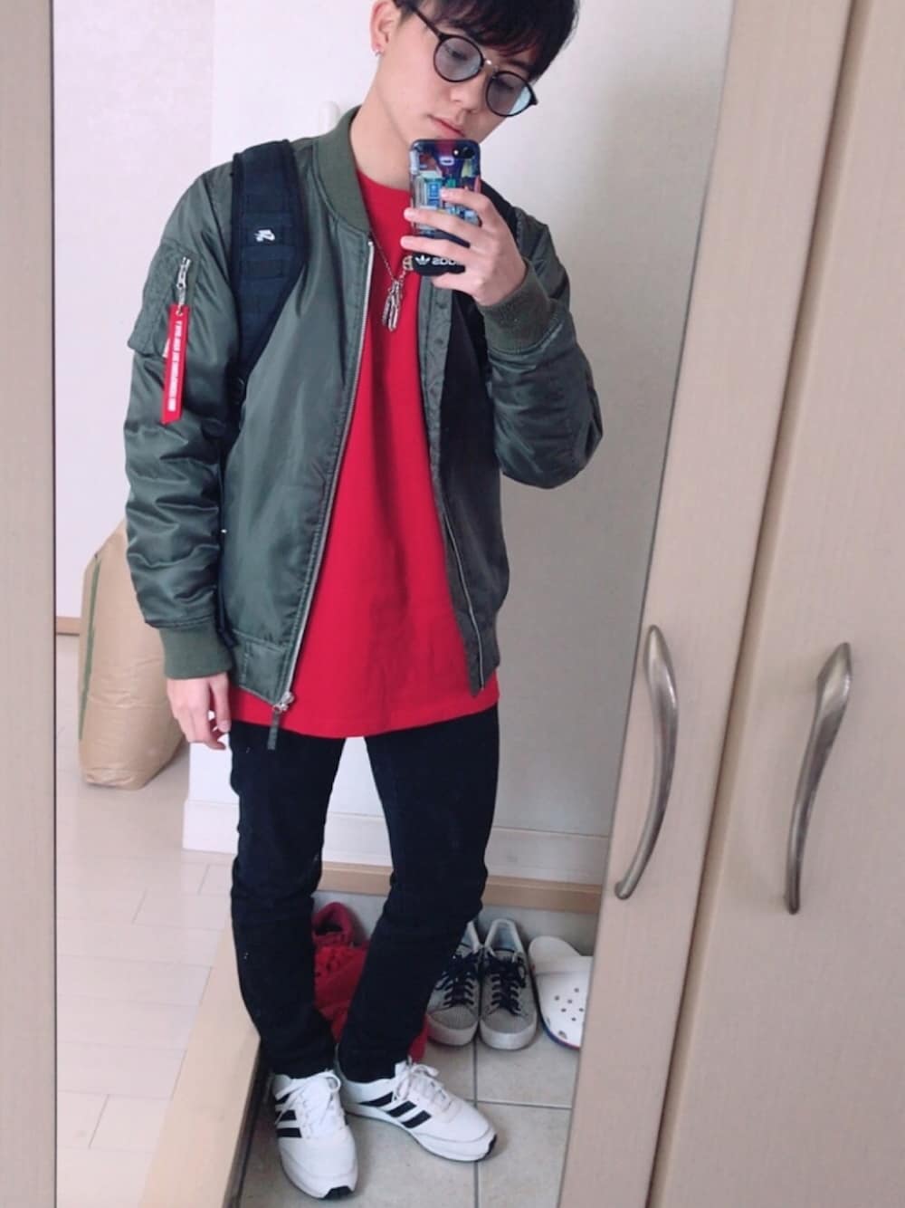 ホワイト系のスニーカー、ブラック系のパンツ、レッド系のTシャツ/カットソーを着用したメンズの冬コーディネートの1枚目の写真