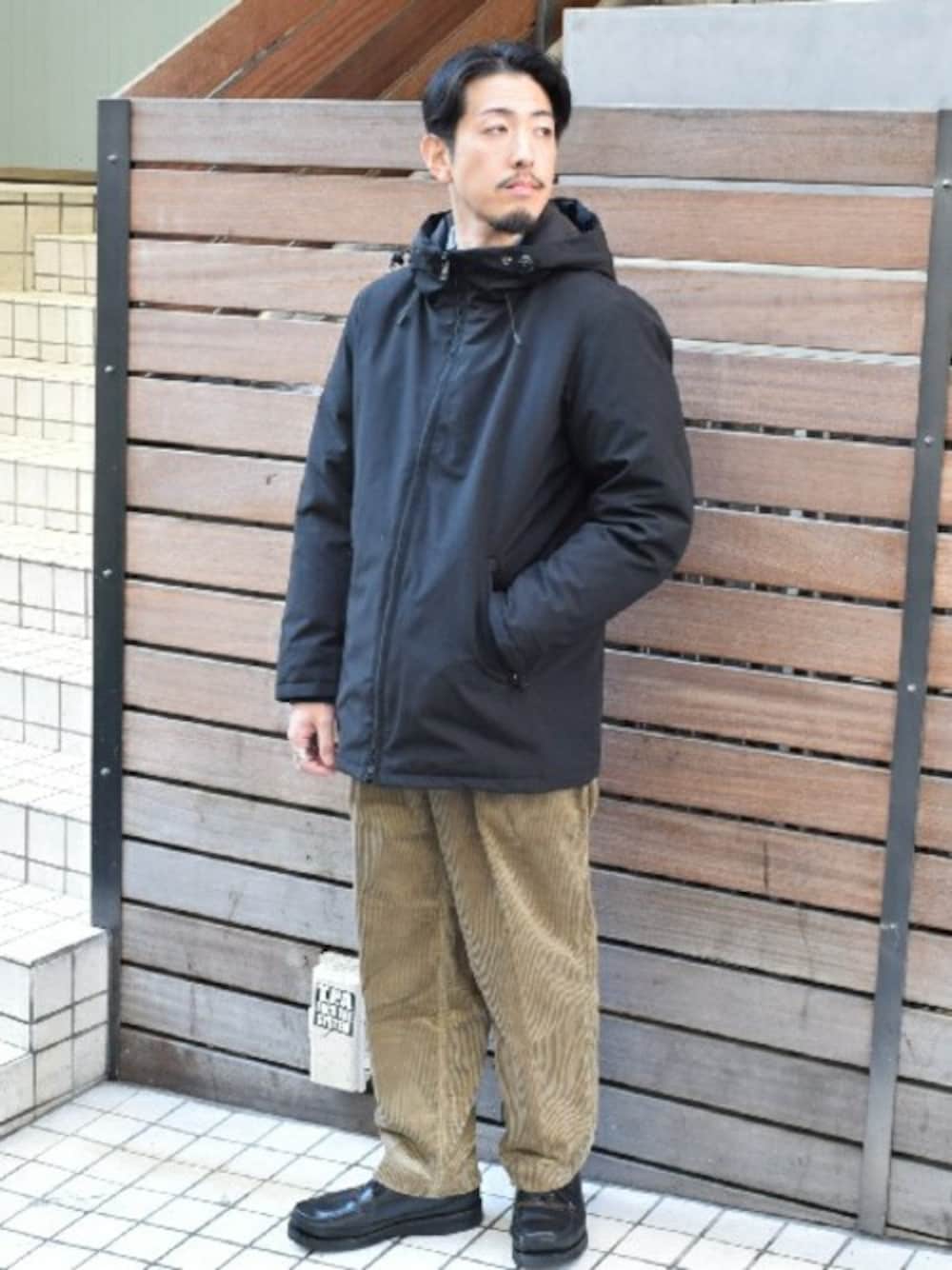 ベージュ系のその他パンツ、ブラック系のダウンジャケット/コートを着用したメンズの冬コーディネートの1枚目の写真