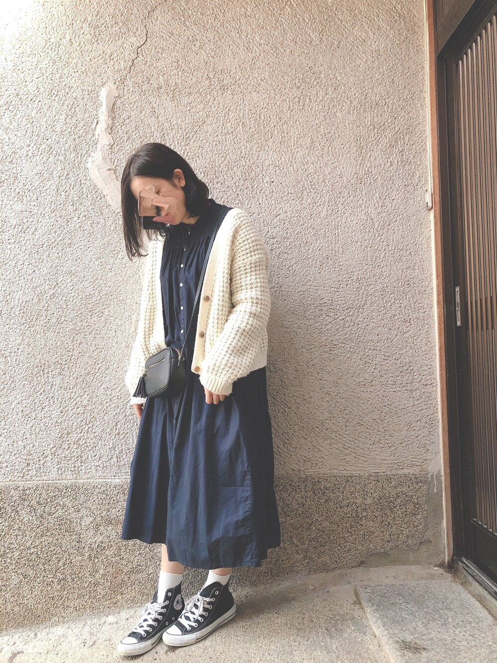 ホワイト系のカーディガン/ボレロ、ブルー系のワンピース/ドレス、ブラック系のスニーカーを着用したレディースの秋コーディネートの1枚目の写真