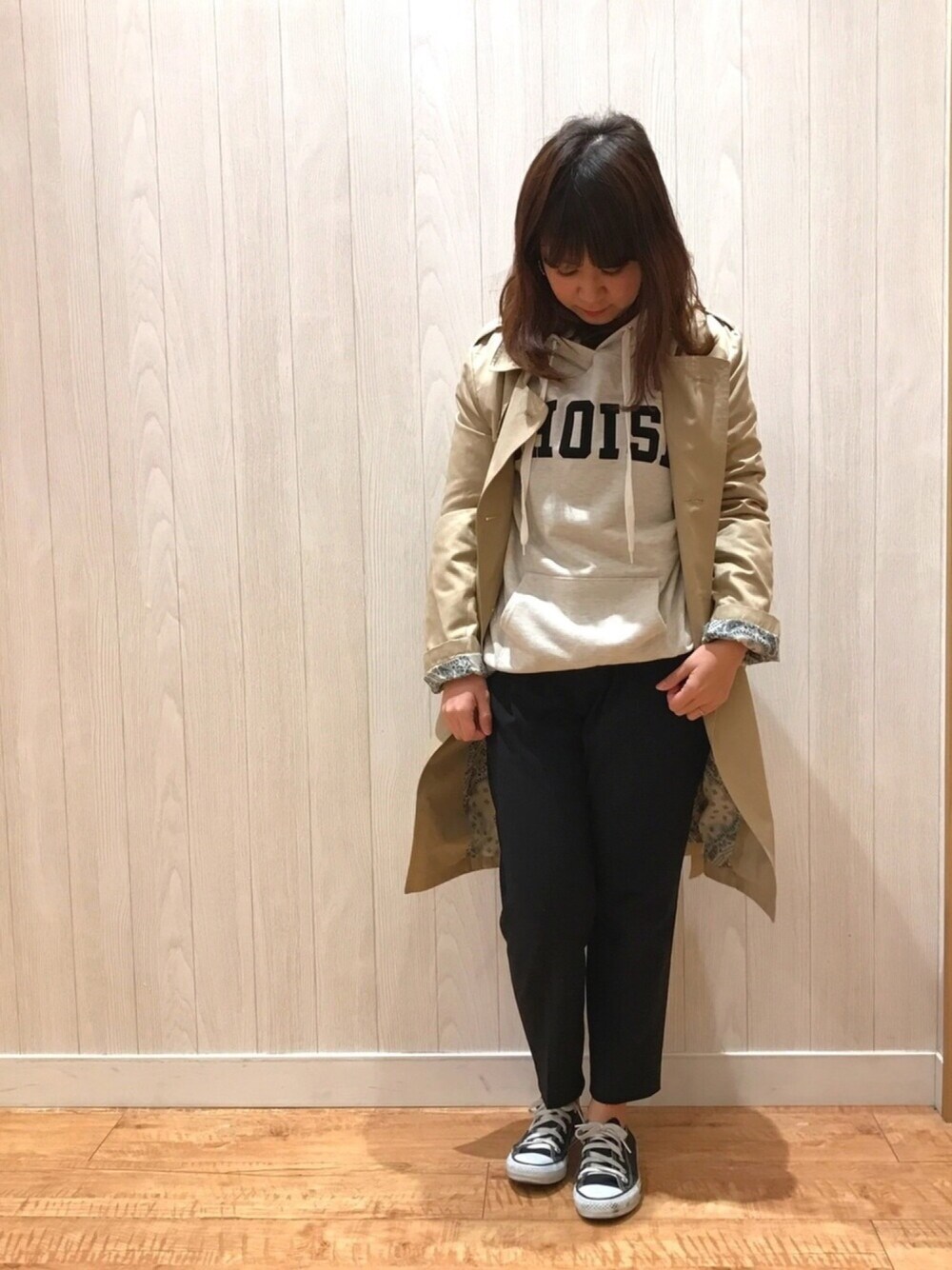 ホワイト系のスウェット、ベージュ系のトレンチコート、ブラック系のその他パンツを着用したレディースの春コーディネートの1枚目の写真