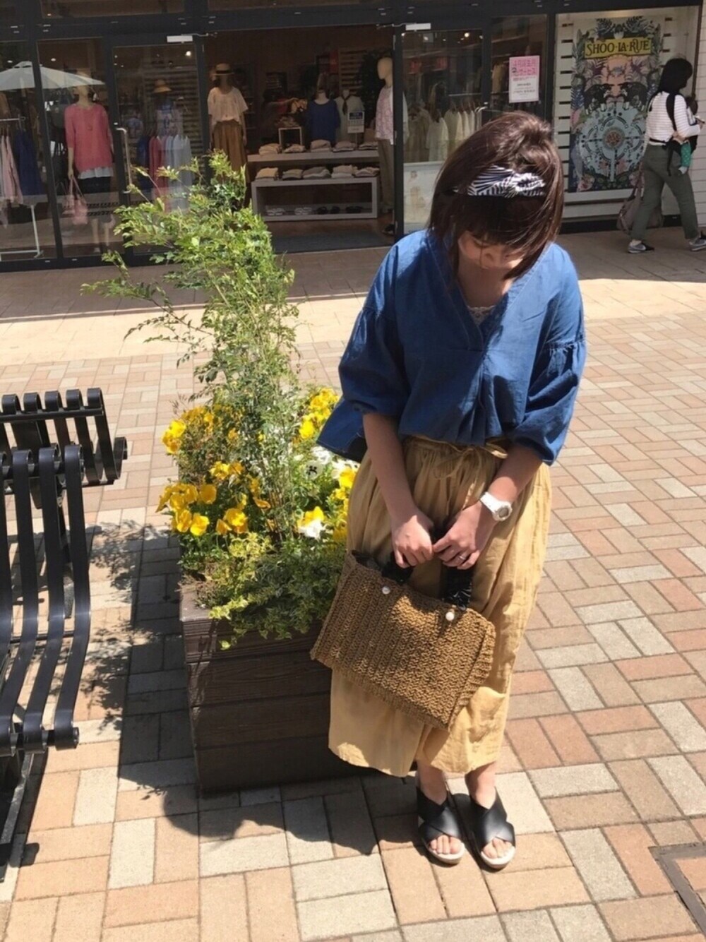 ブルー系のシャツ/ブラウス、ブラック系のサンダル、ブラック系のトートバッグを着用したレディースの春コーディネートの1枚目の写真