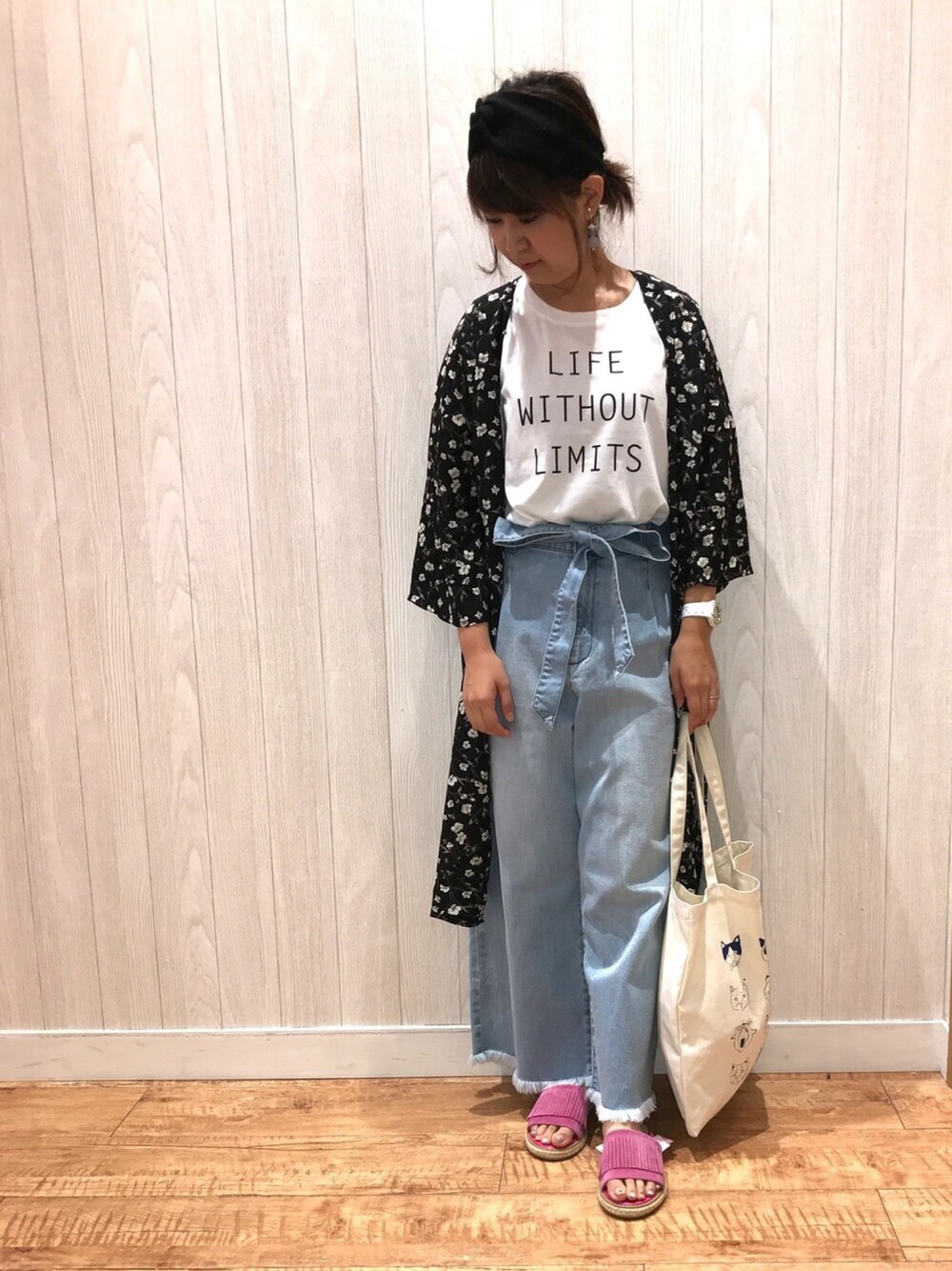 ブルー系のデニムパンツ、ピンク系のサンダル、ブラック系のその他トップスを着用したレディースの夏コーディネートの1枚目の写真