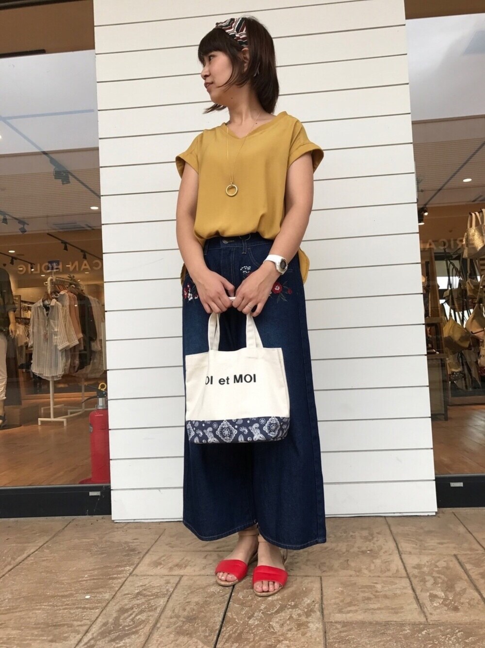 イエロー系のシャツ/ブラウス、ブルー系のトートバッグ、レッド系のサンダルを着用したレディースの夏コーディネートの1枚目の写真