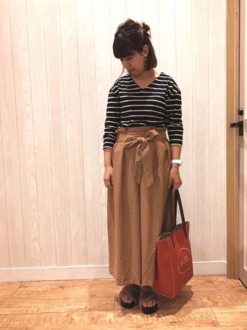 レッド系のトートバッグ、ピンク系のサンダル、ブラウン系のその他パンツを着用したレディースの夏コーディネートの1枚目の写真