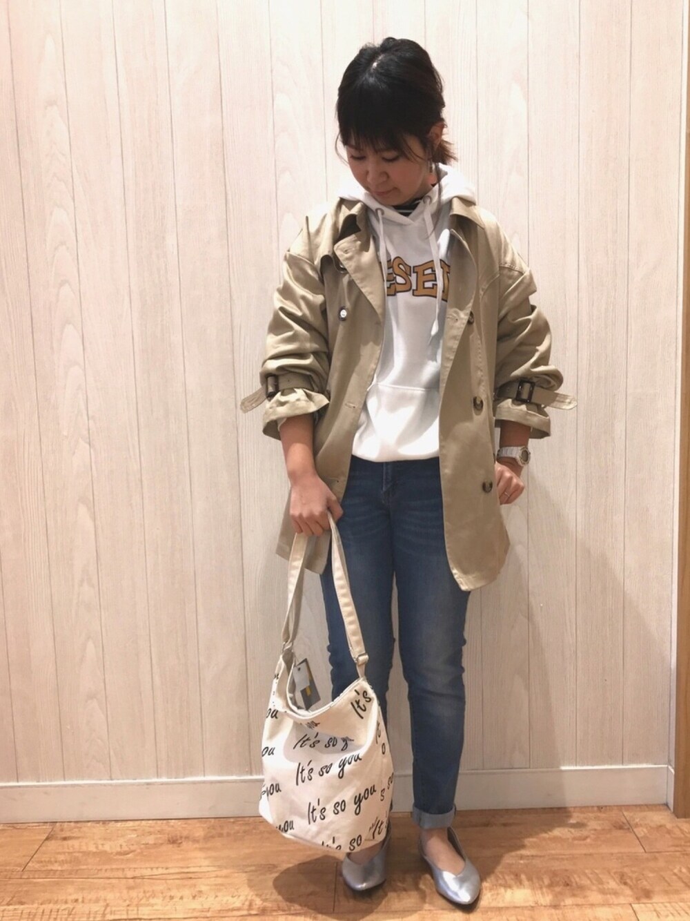 ブルー系のデニムパンツ、シルバー系のパンプス、ホワイト系のショルダーバッグを着用したレディースの冬コーディネートの1枚目の写真