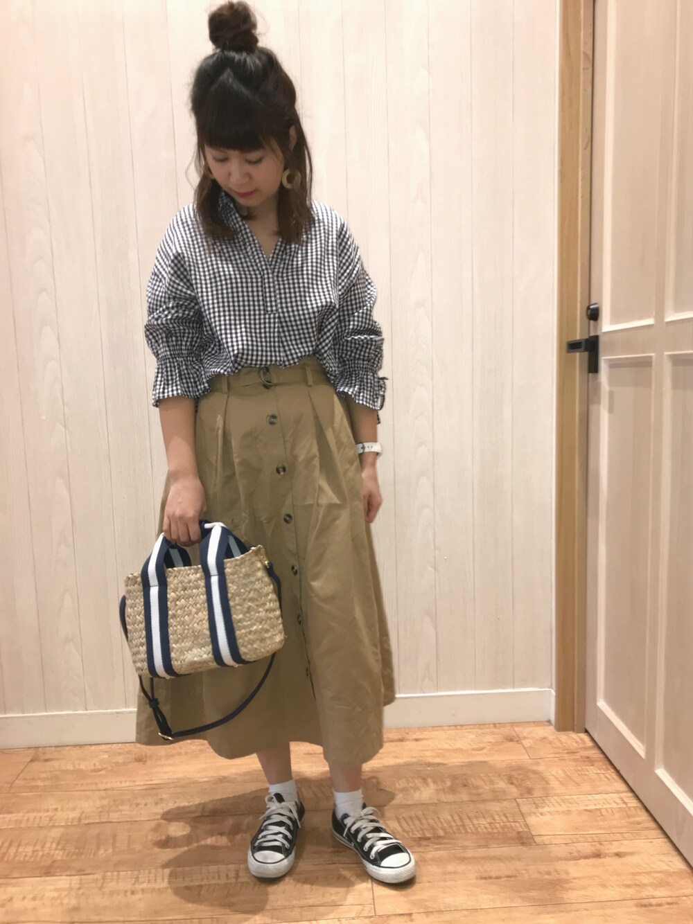 ブラック系のシャツ/ブラウス、ベージュ系のスカート、ブルー系のショルダーバッグを着用したレディースの春コーディネートの1枚目の写真