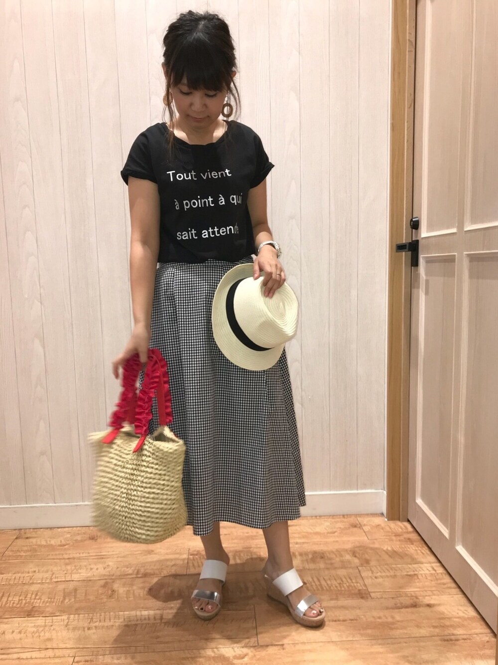 ブラック系のTシャツ/カットソー、ブラック系のスカート、ホワイト系のサンダルを着用したレディースの夏コーディネートの1枚目の写真