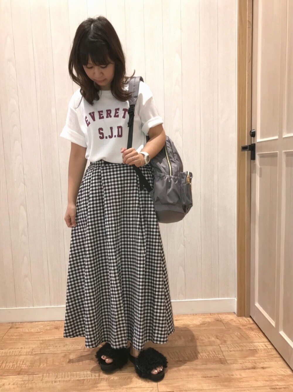 ホワイト系のワンピース、ブラック系のスカート、ブラック系のサンダルを着用したレディースの夏コーディネートの1枚目の写真