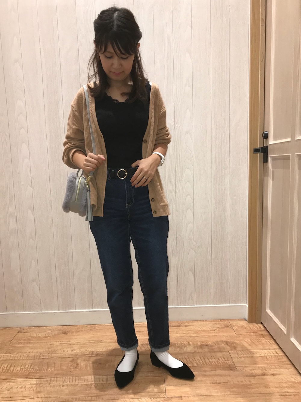 ブラウン系のカーディガン/ボレロ、ブラック系のタンクトップ、ブルー系のデニムパンツを着用したレディースの夏コーディネートの1枚目の写真