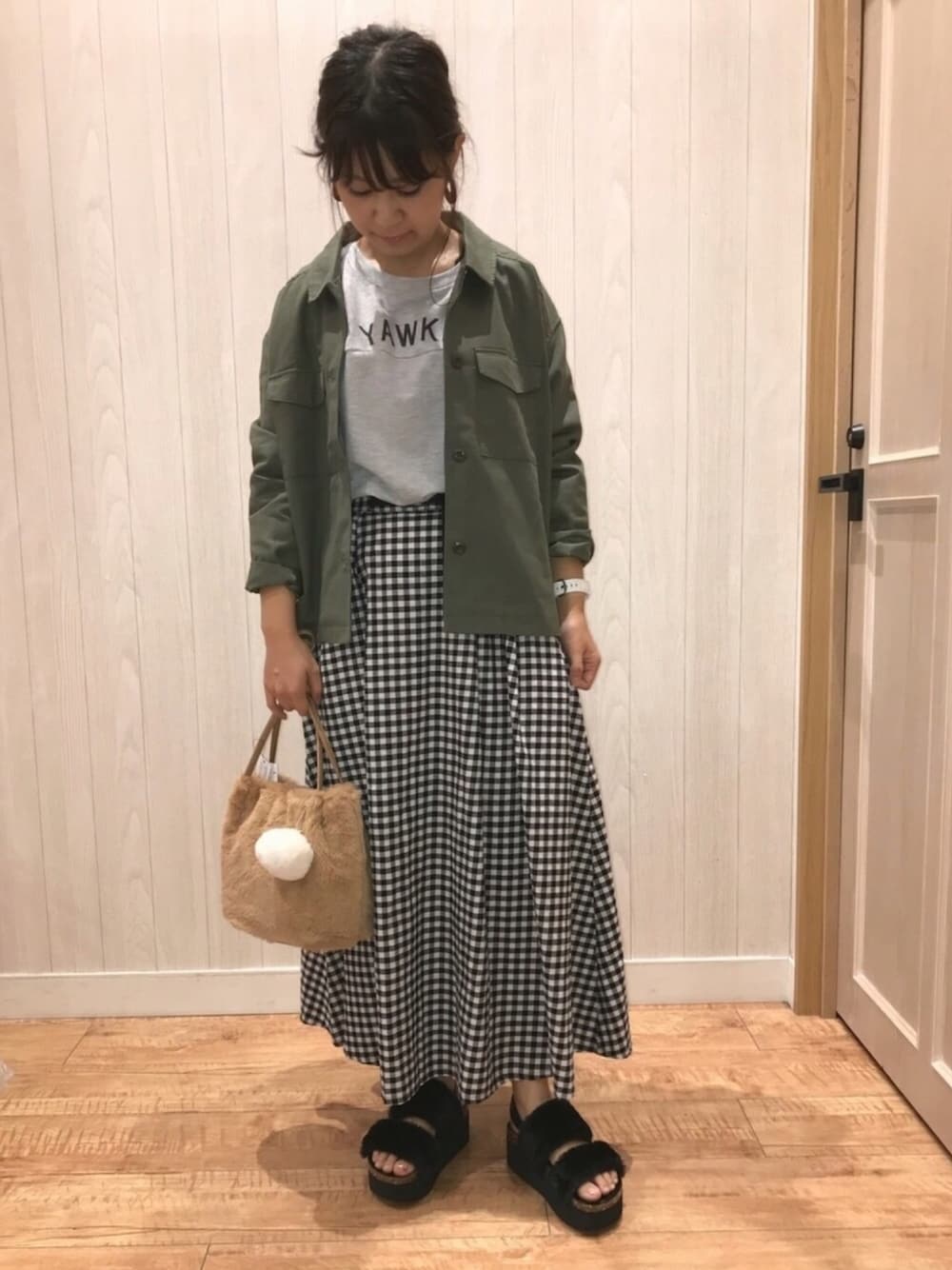 グレー系のスウェット、ブラック系のスカート、ベージュ系のショルダーバッグを着用したレディースの秋コーディネートの1枚目の写真