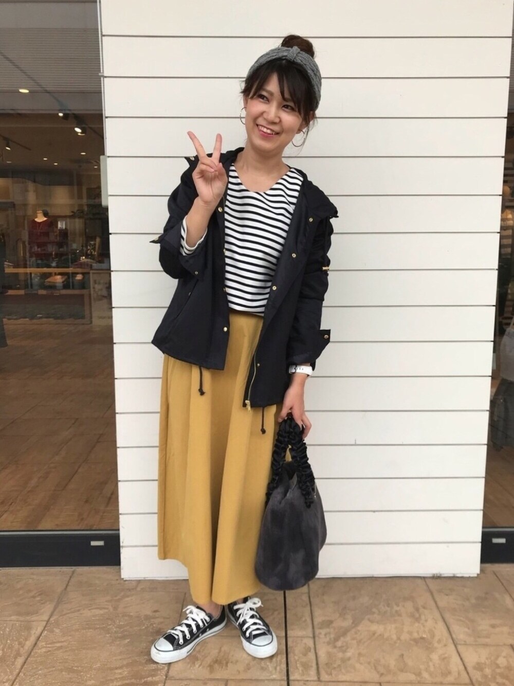 ホワイト系のTシャツ/カットソー、グレー系のトートバッグ、ブルー系のミリタリージャケットを着用したレディースの秋コーディネートの1枚目の写真