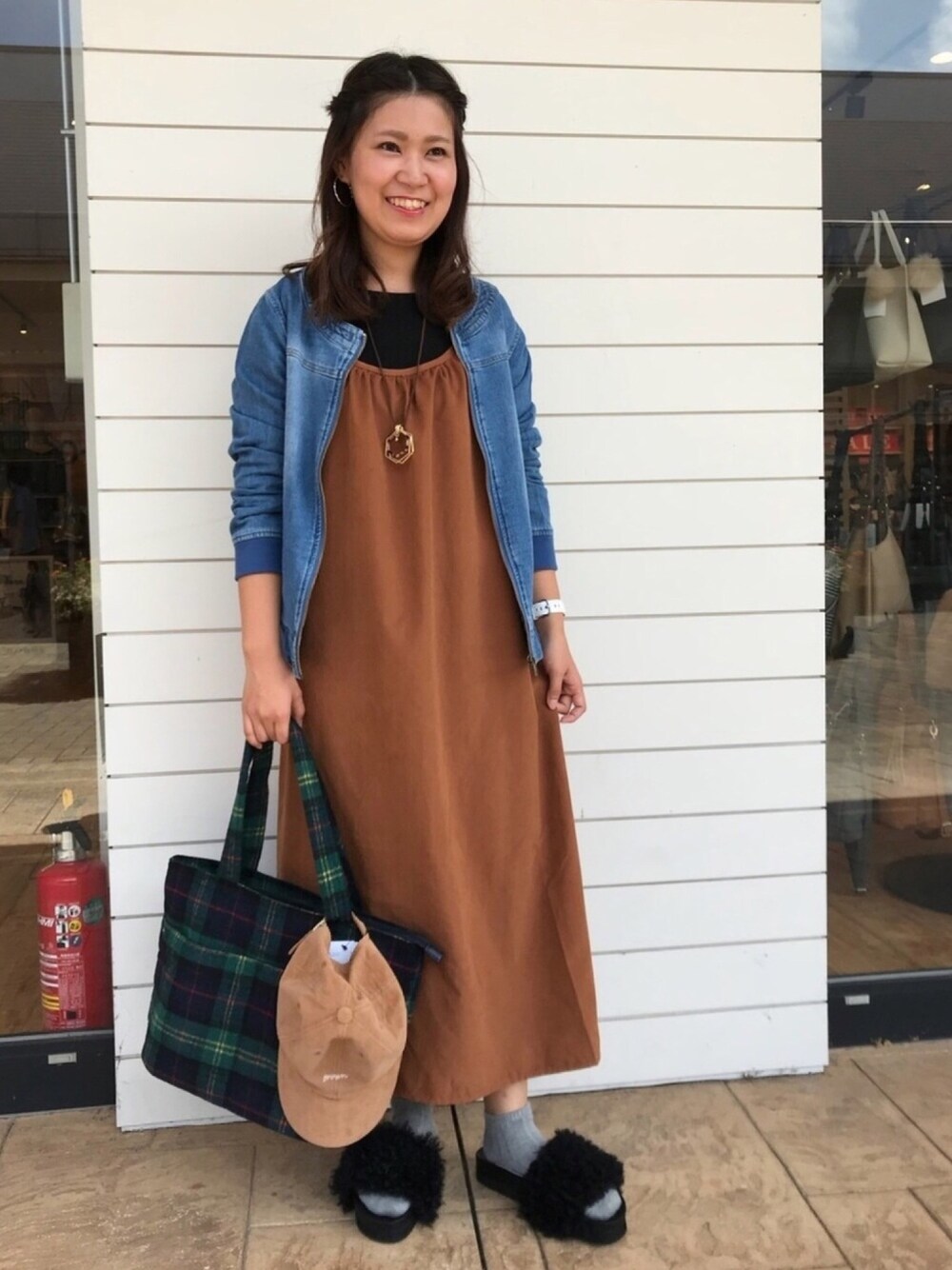 ブラック系のサンダル、グリーン系のトートバッグ、ブルー系のブルゾンを着用したレディースの秋コーディネートの1枚目の写真