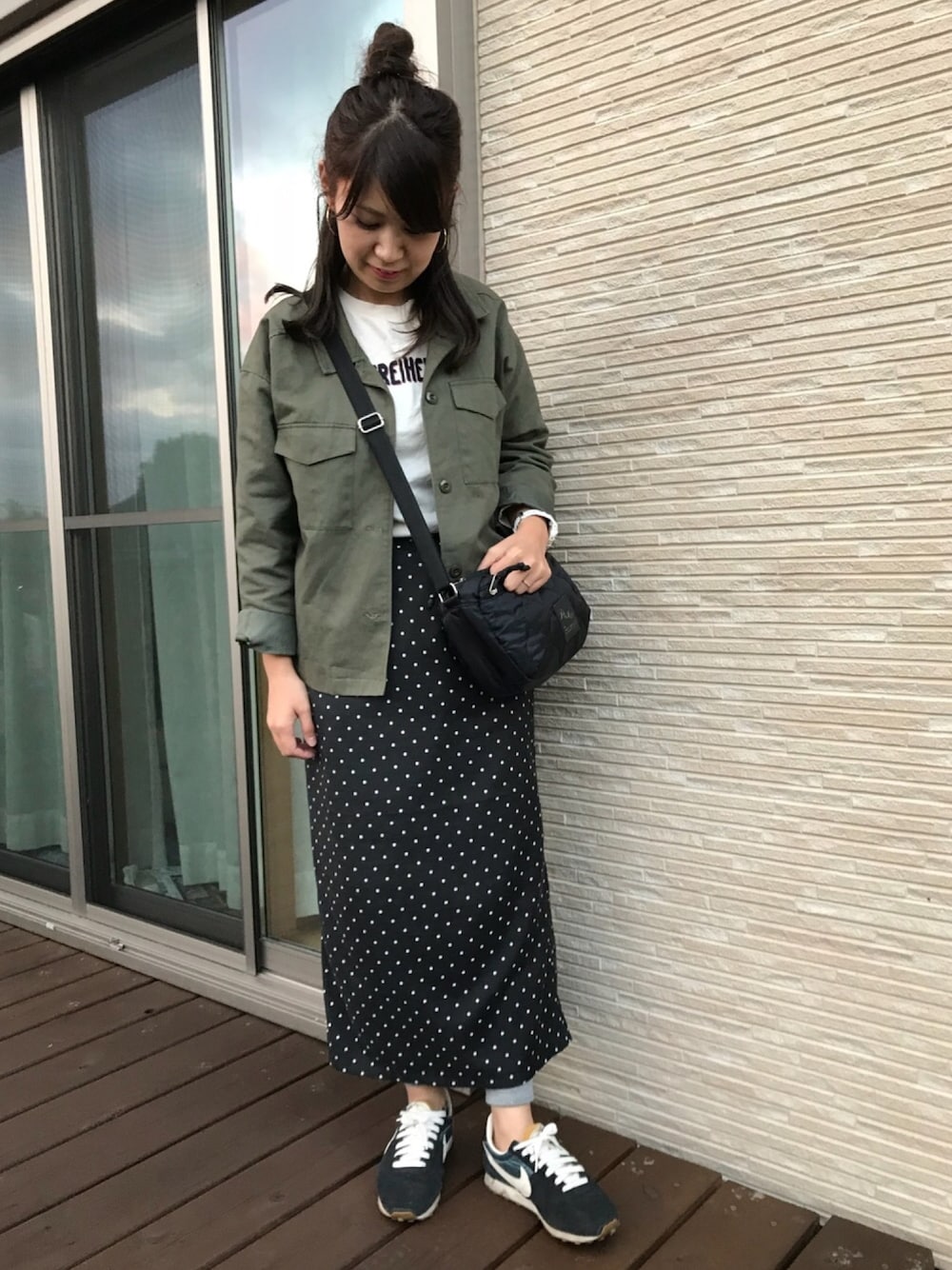 グリーン系のミリタリージャケットを着用したレディースの秋コーディネートの1枚目の写真