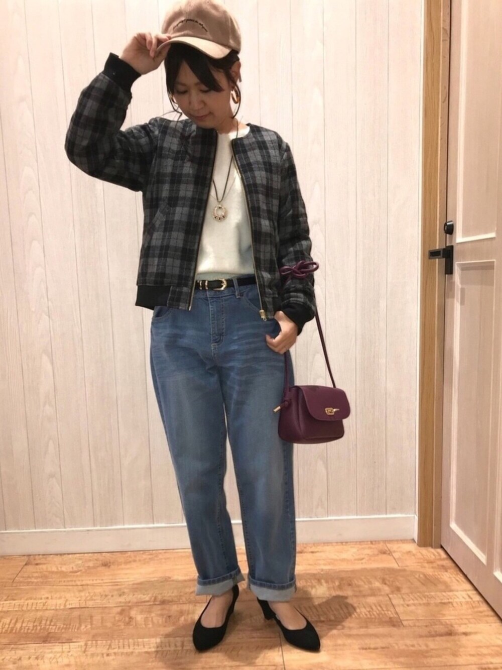 ブラック系のブルゾン、ブルー系のデニムパンツ、ブラック系のパンプスを着用したレディースの秋コーディネートの1枚目の写真