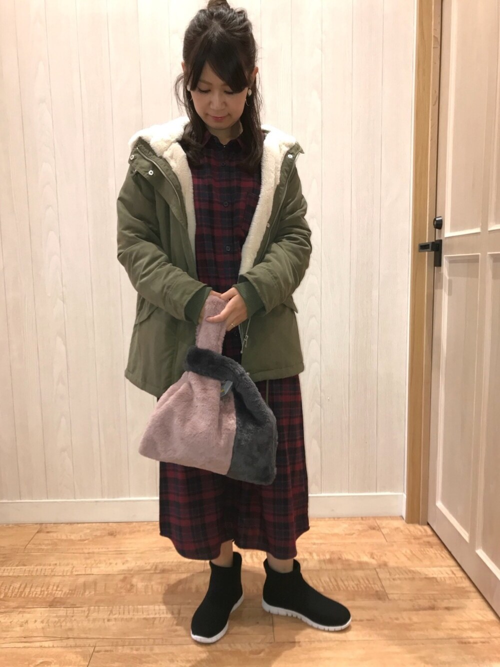 レッド系のワンピース、ピンク系のトートバッグ、グリーン系のモッズコートを着用したレディースの秋コーディネートの1枚目の写真